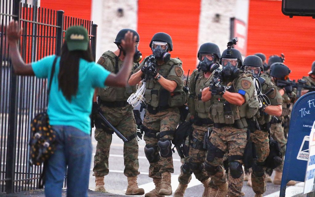 "A black man being confronted by a military team"