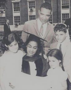 Black and white image of DeCosta-Willis standing outside, wearing a graduation cap and gown.