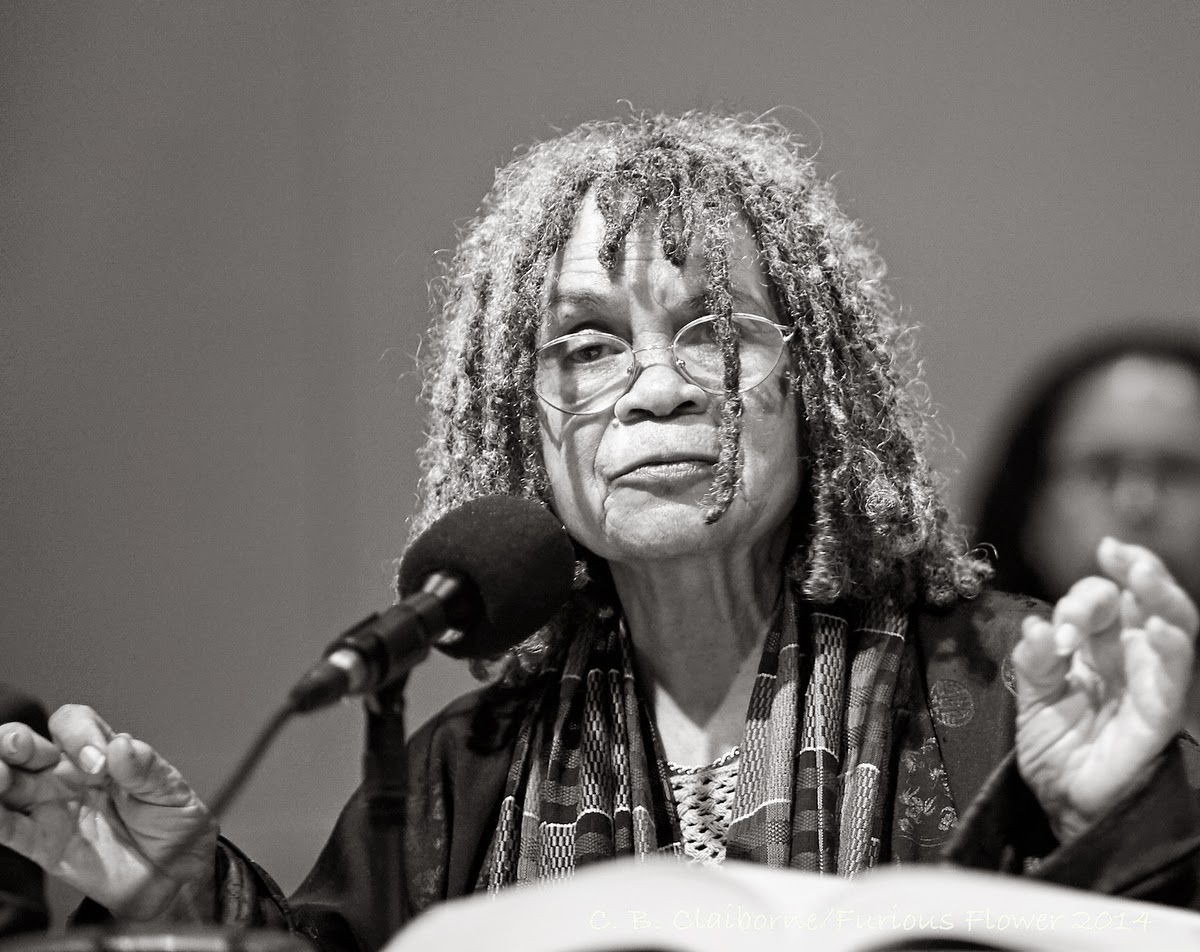 "A black and white image of a woman speaking at the podium"