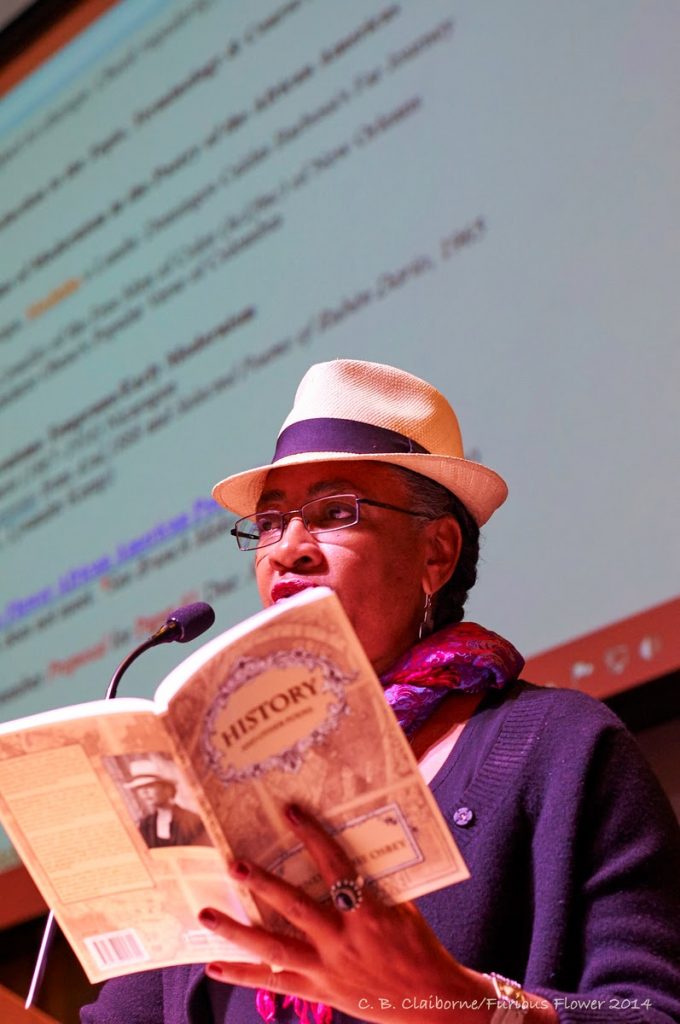 "A woman reading a book on stage"