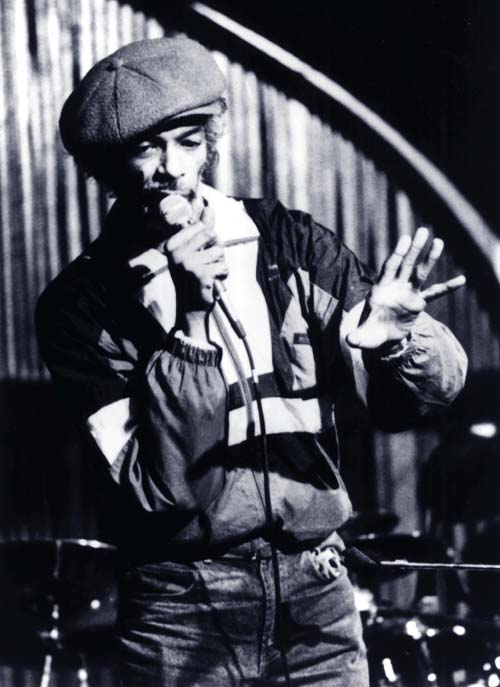 "Black and White photo of Gil Scott-Herron singing on stage"