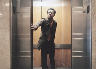 "Colson Whitehead holding the door of an elevator"