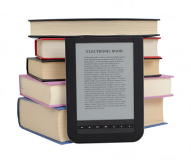 "A Kindle laying against a stack of books"