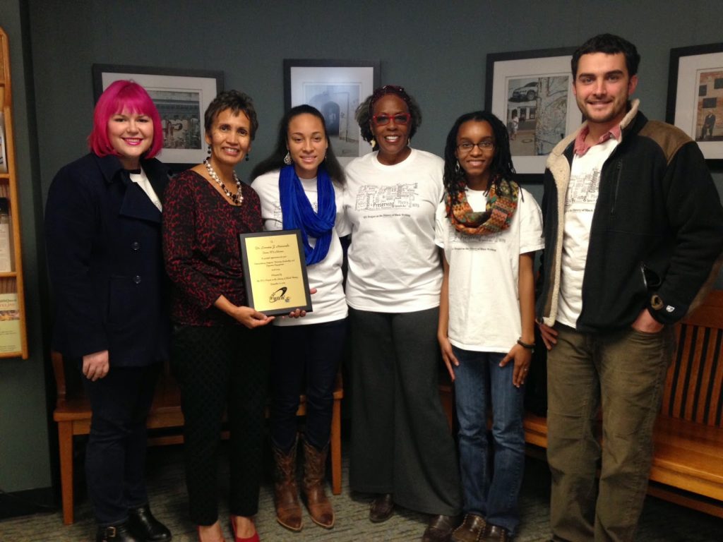 "HBW staff members present KU Dean of Libraries Lorraine Haricombe with a plaque in appreciation of her support.	"