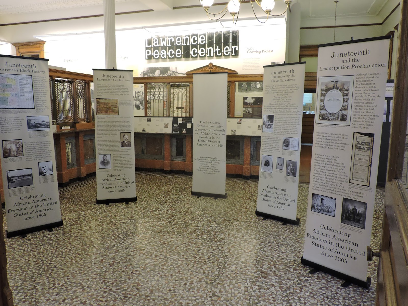 Five flag stands of information in Lawrence Peace Center