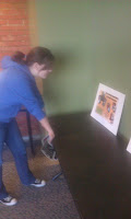 "A woman in a blue hoodie looking at the Black Literary Report on a table"