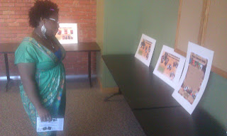 ""A woman in a green top looking at the Black Literary Report on a table""